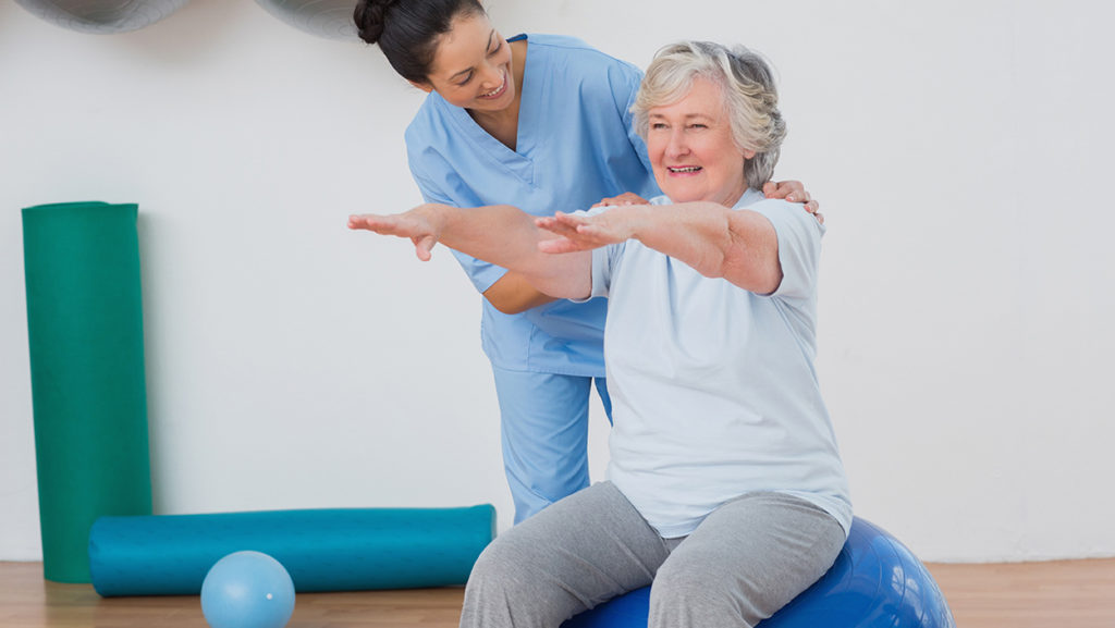 movement analysis physical therapy Happy instructor assisting senior woman in exercising at gym